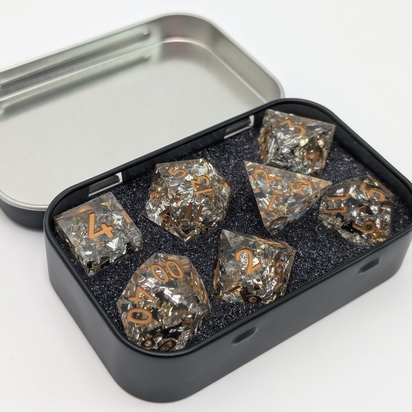 Gold Foil Dice Set inside of metal dnd dice storage tin seperated by foam.