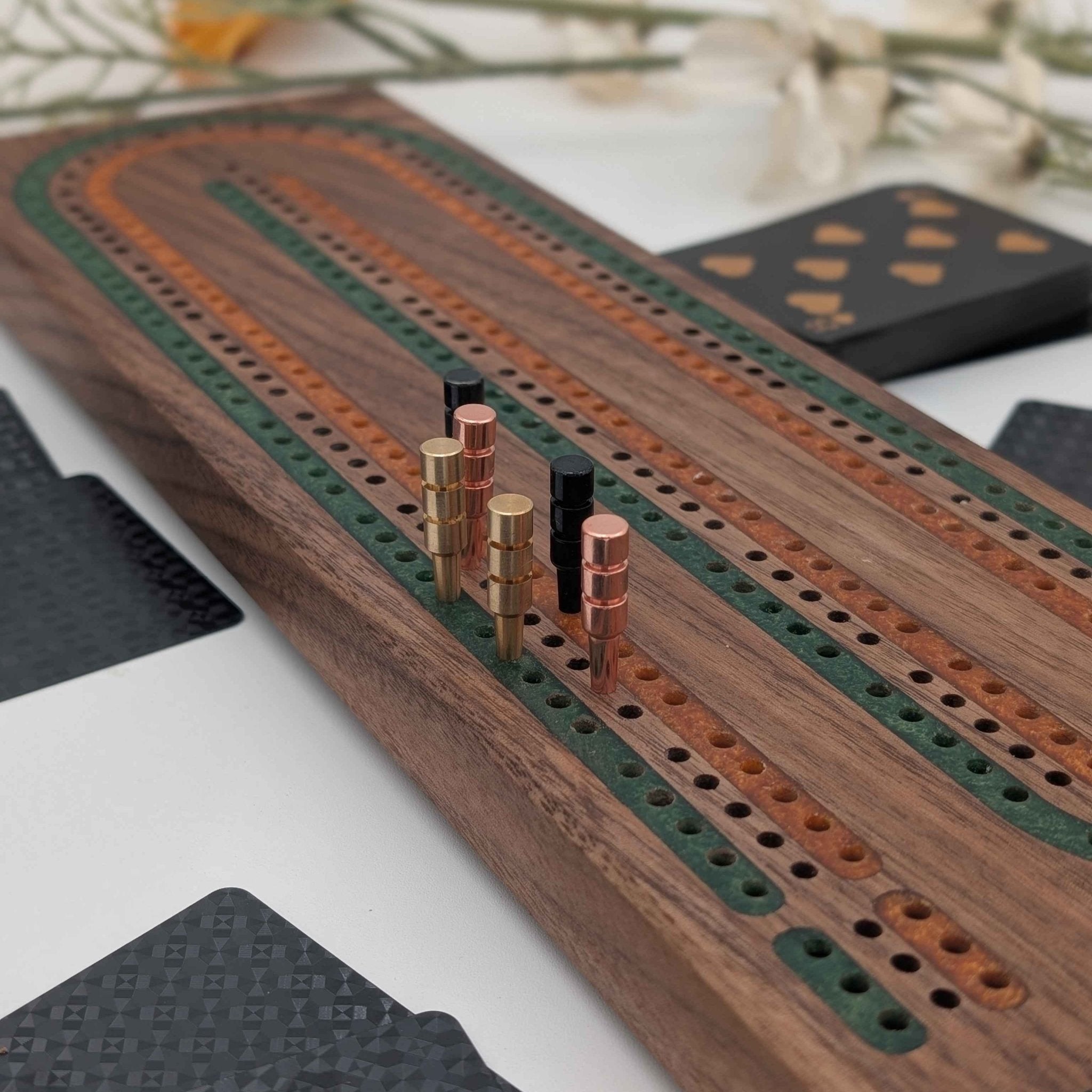 Walnut 3 player cribbage board with multi-color inlays in walnut wood on white background with flowers.