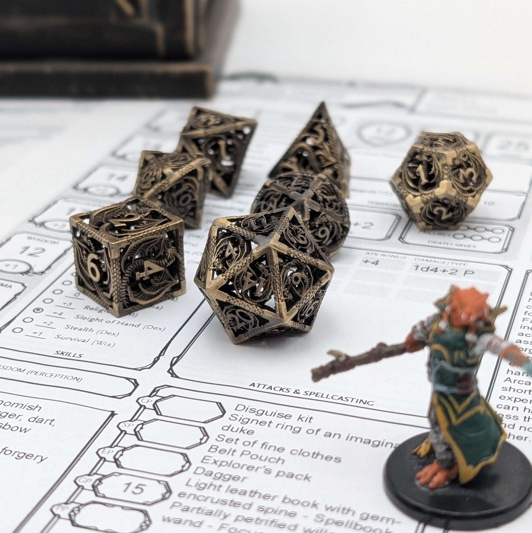 Brass DnD dice with engraved dragon scales and hollow chimes for rolling