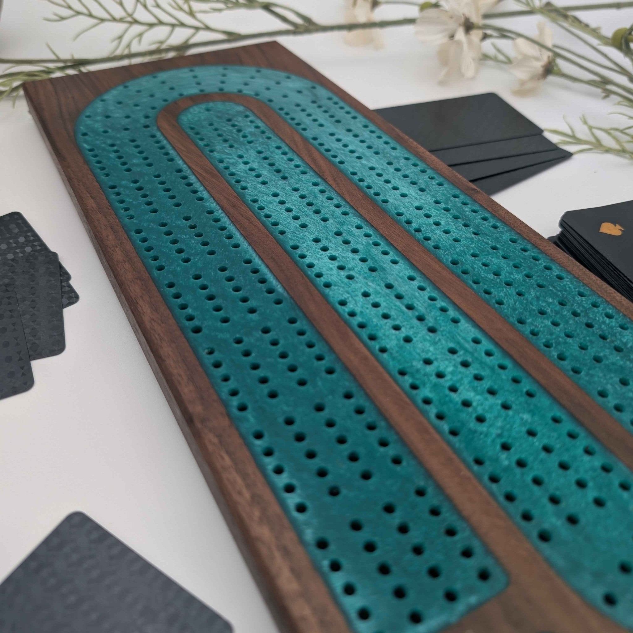 Luxury Walnut Cribbage Board with Emerald Resin Inlay with pegs and cards on white background