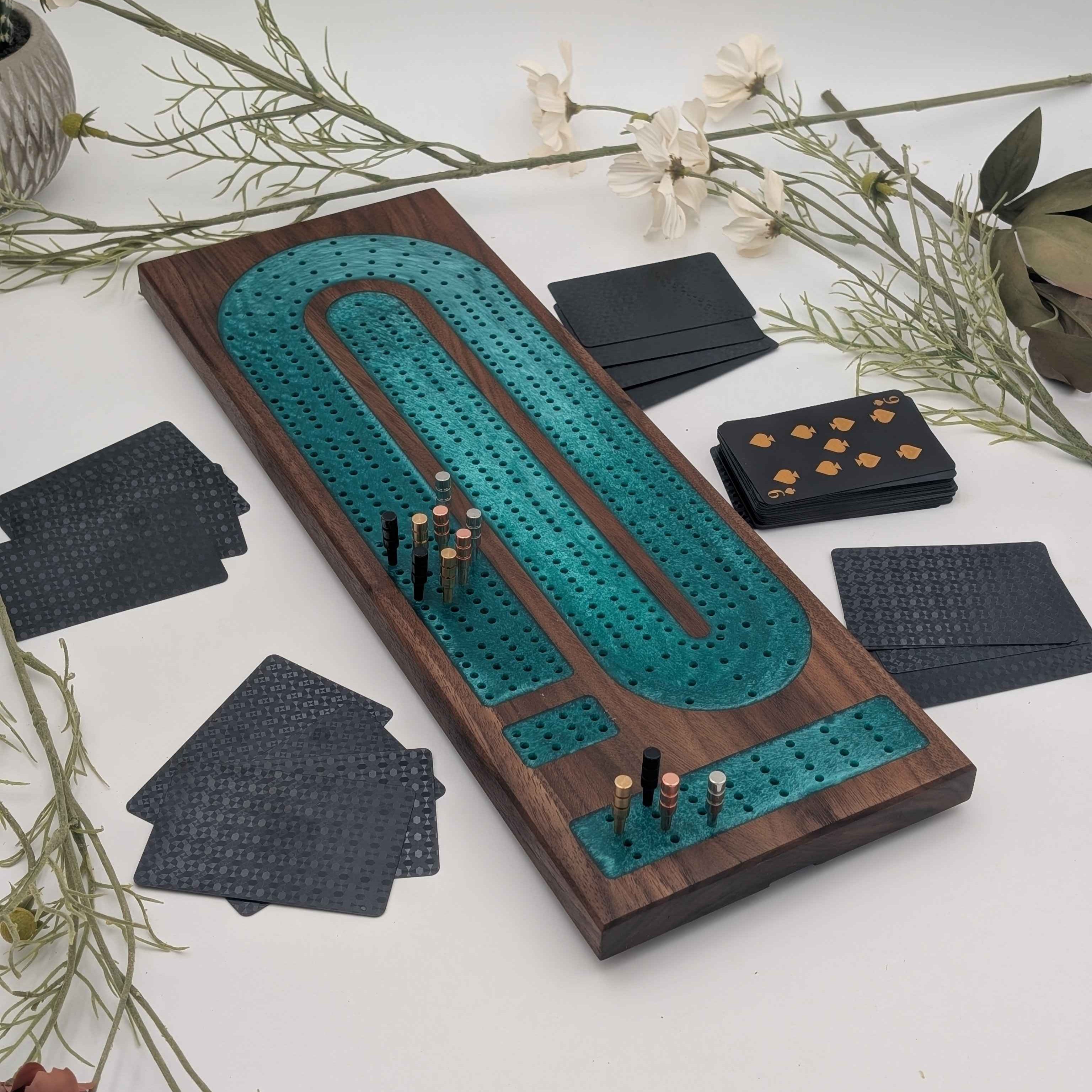 Luxury Walnut Cribbage Board with Emerald Resin Inlay with pegs and cards on white background