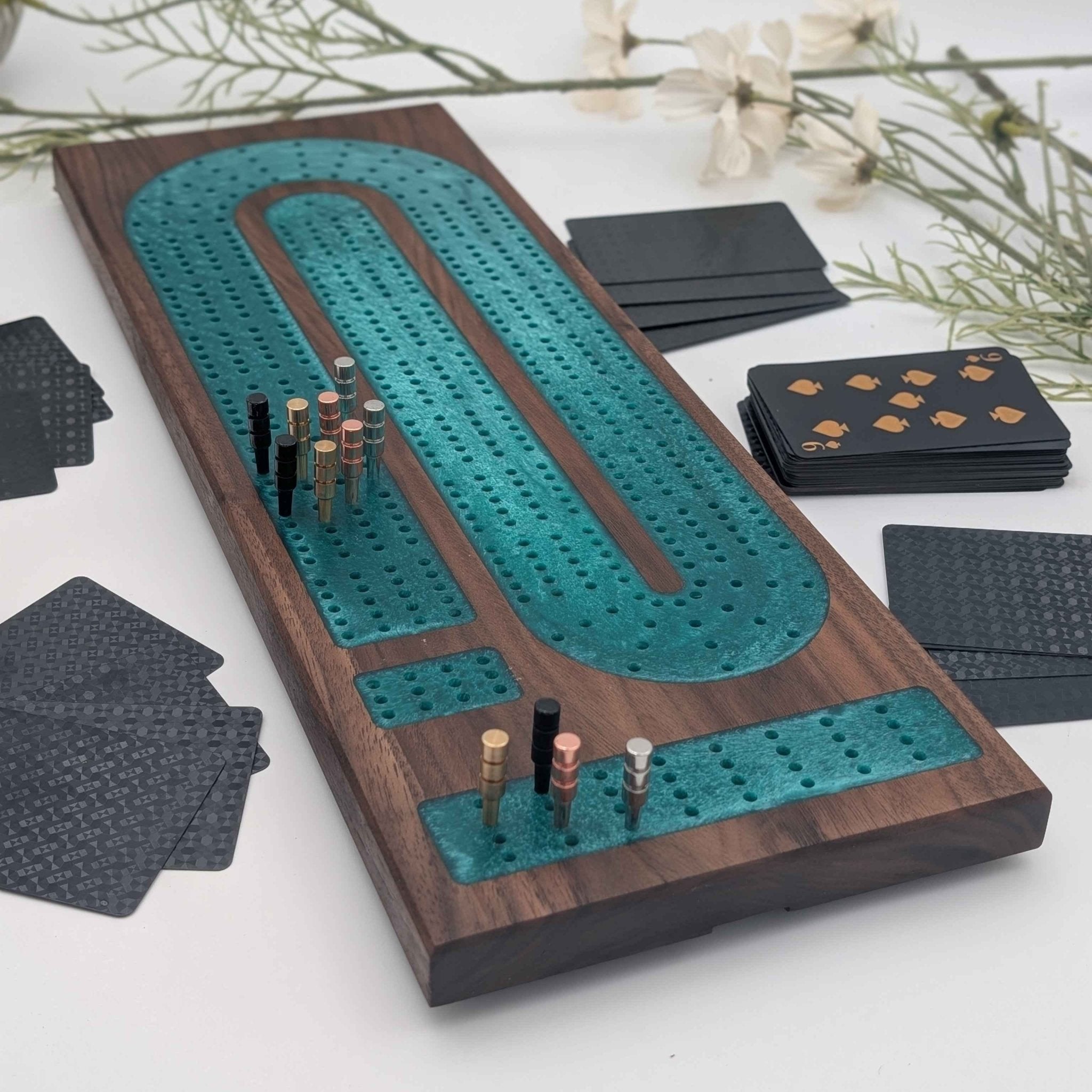 Luxury Walnut Cribbage Board with Emerald Resin Inlay with pegs and cards on white background