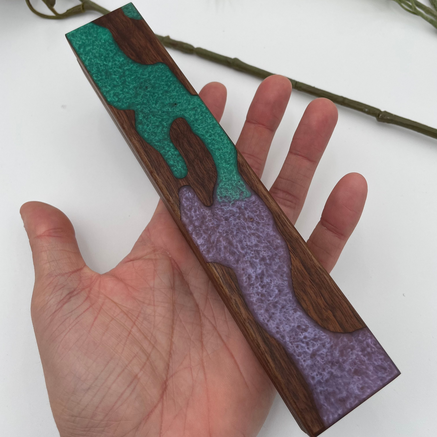 purple and green resin dice vault held in hand