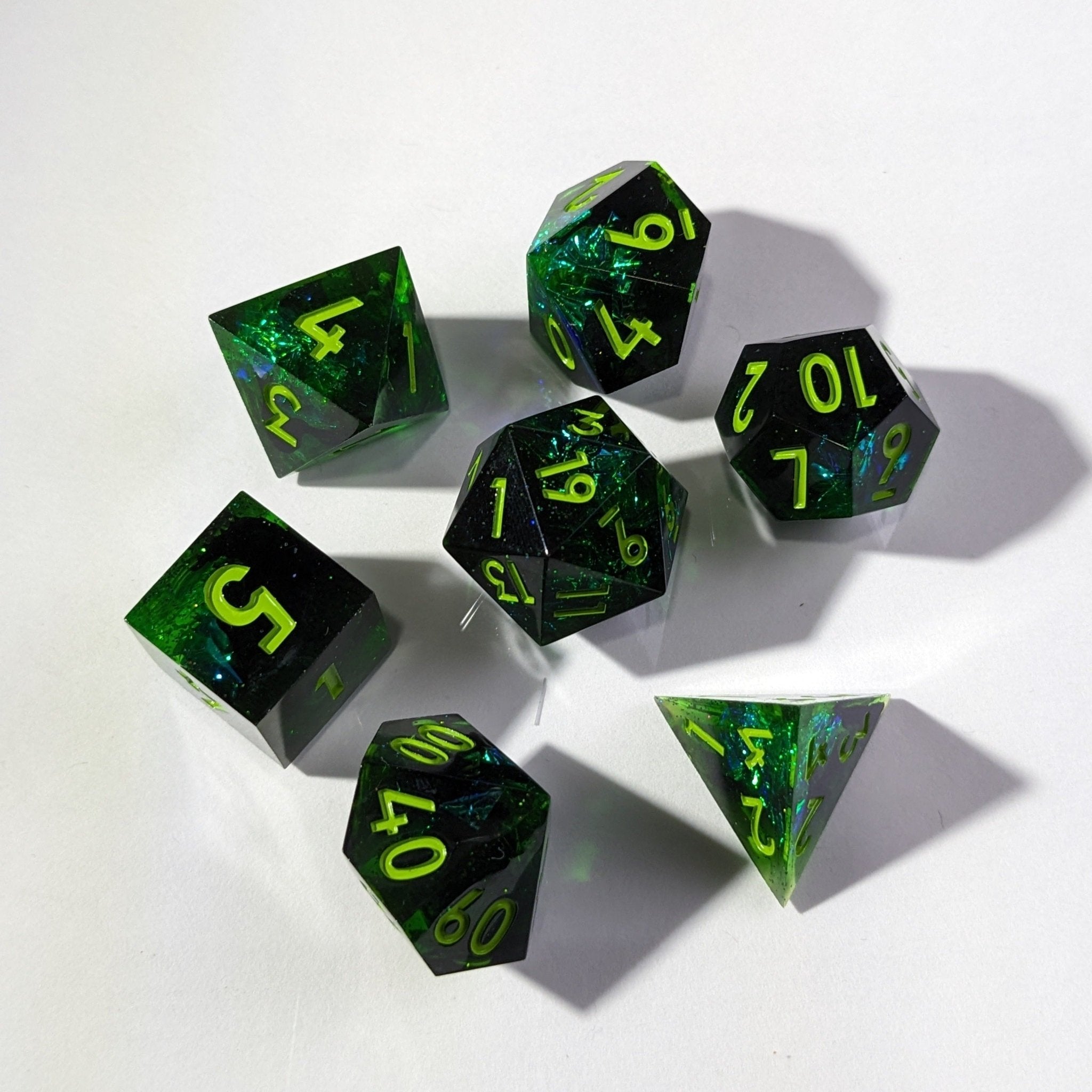 Set of green and black dice with yellow numbers on a white background