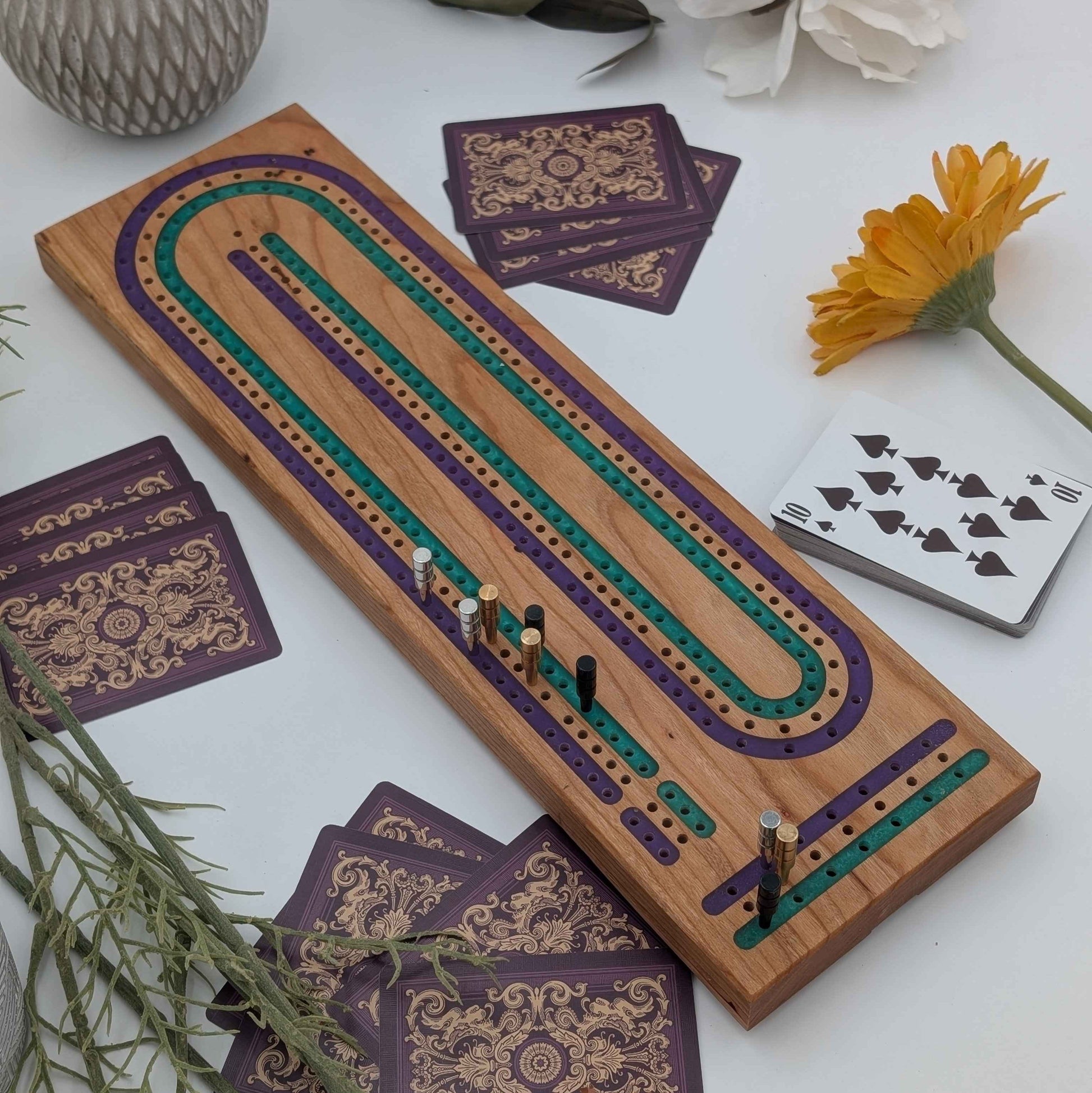 Handcrafted Cribbage board made of cherry wood featuring a 3 track resin inlay of purple and green tracks