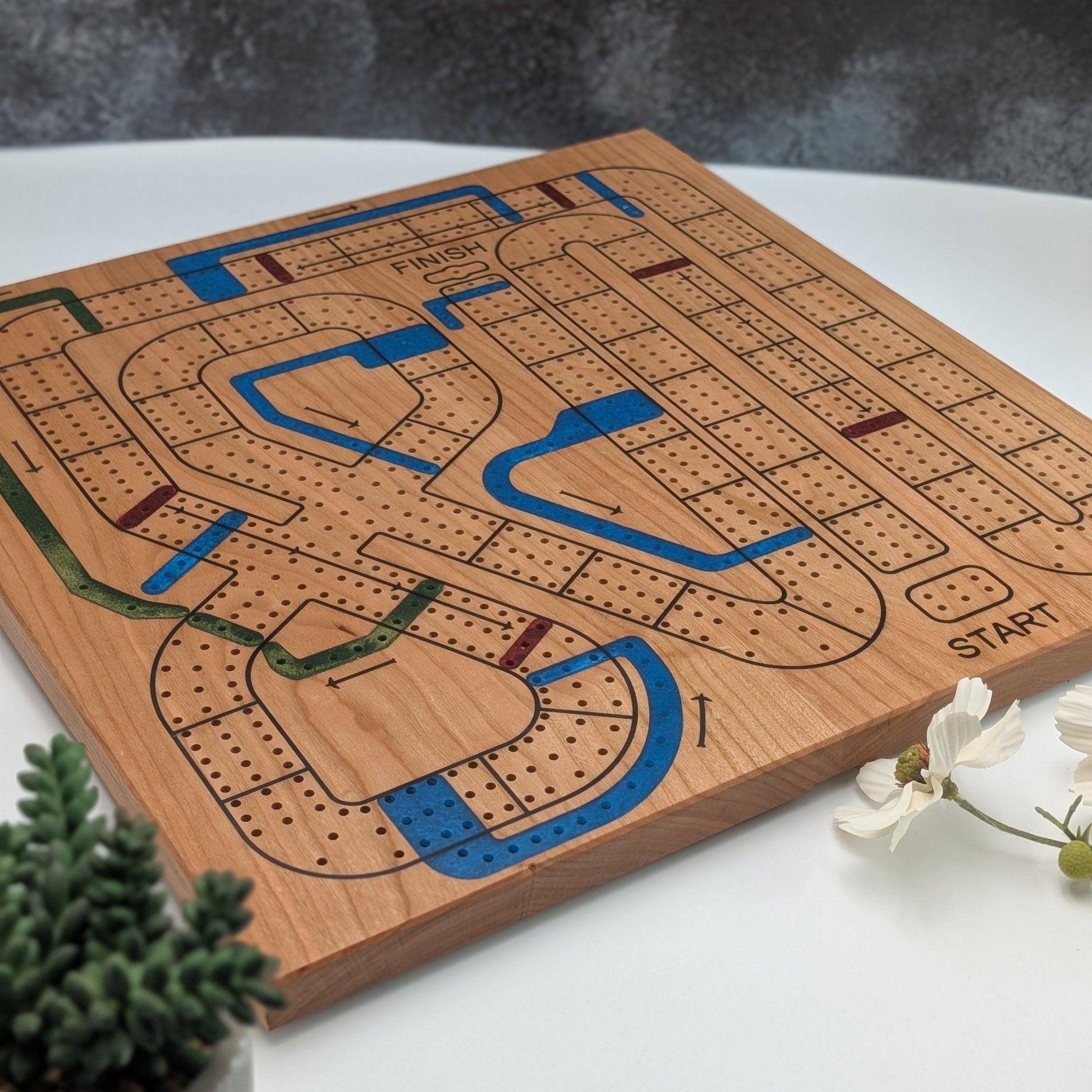 handmade cribbage wars board on white background with flowers and a black blackdrop