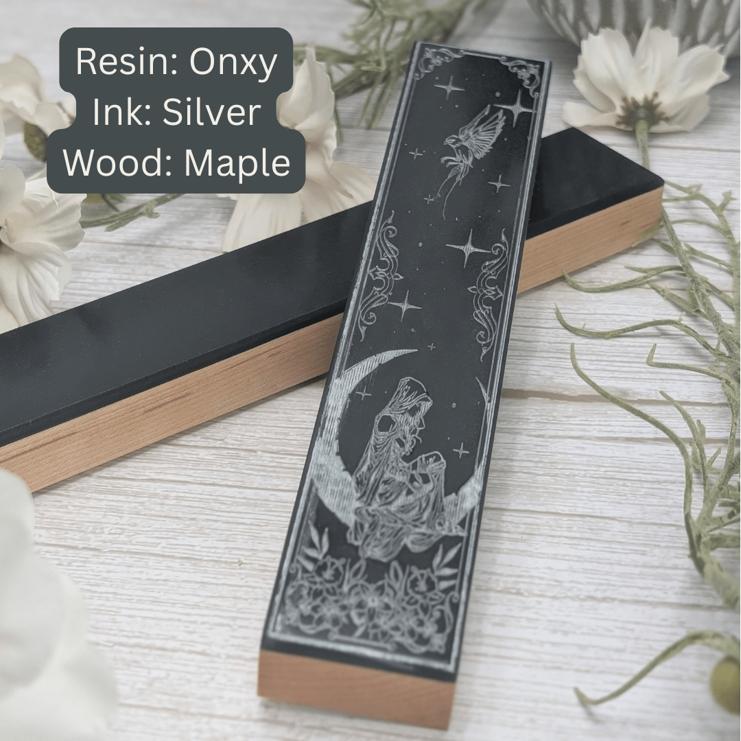 Decorative dice vault with resin onyx, silver ink, and maple wood on a light wooden surface.