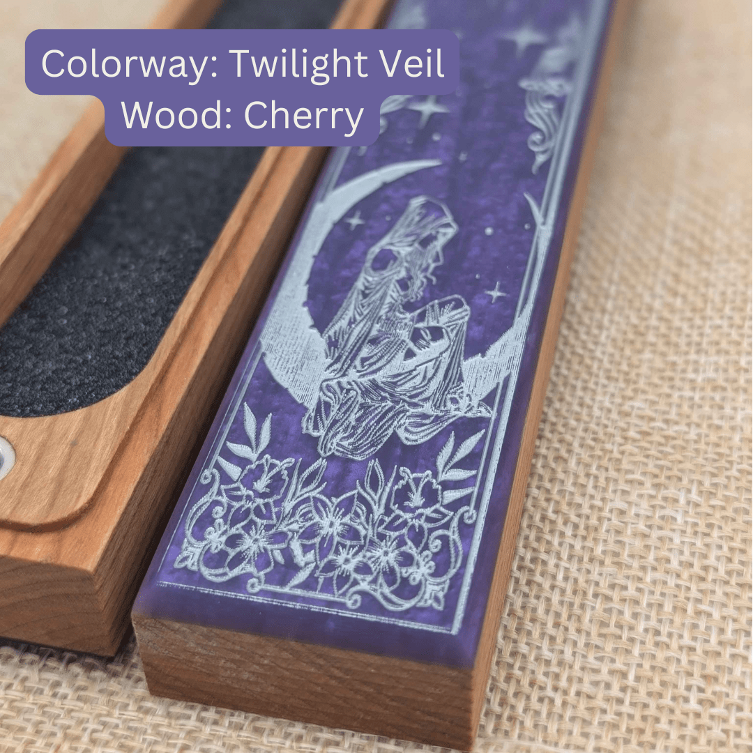 Wooden dice vault with purple resin featuring a design of a woman and moon, on a textured fabric background.