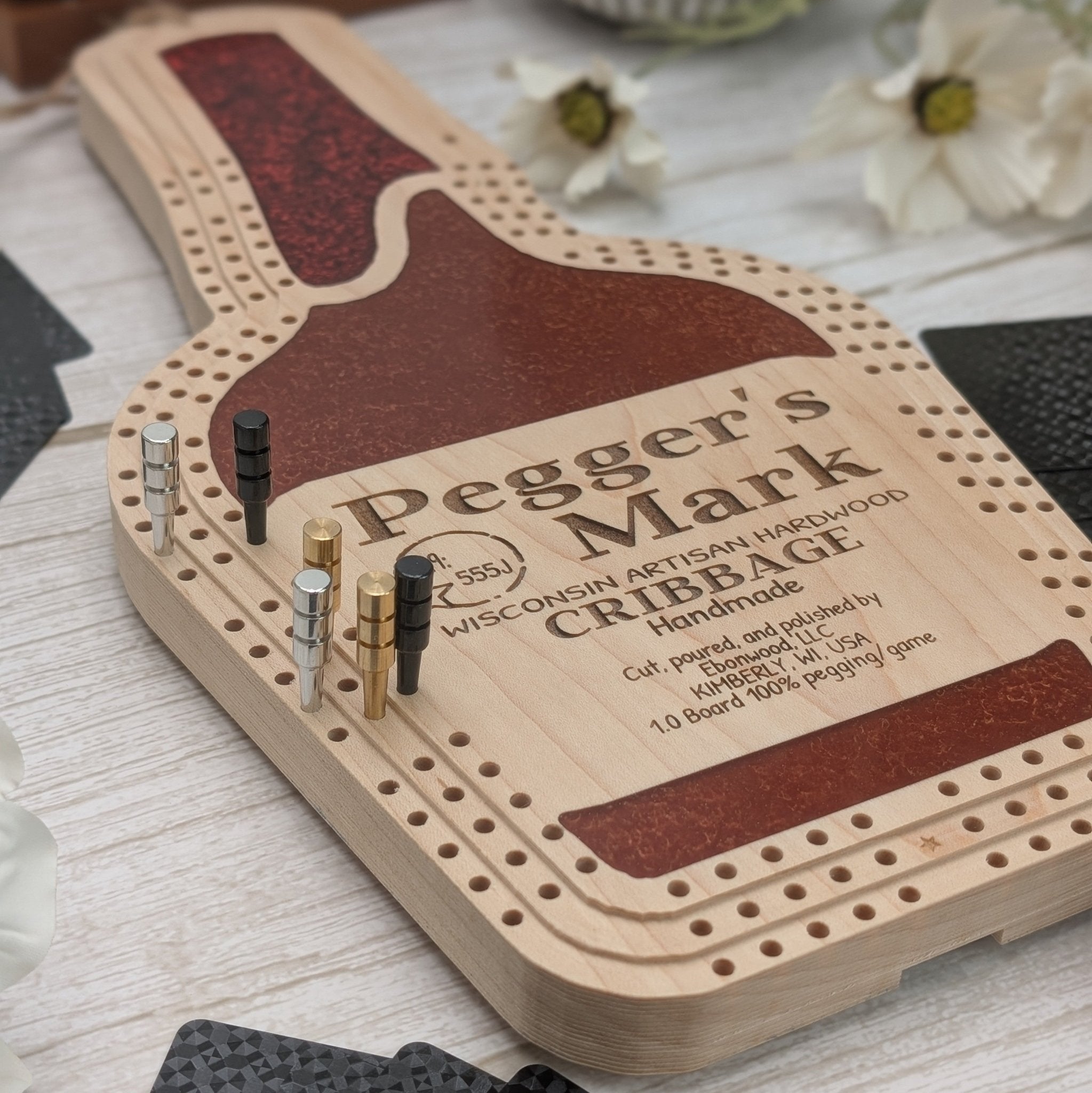 Wooden cribbage board with pegs on a light wooden surface