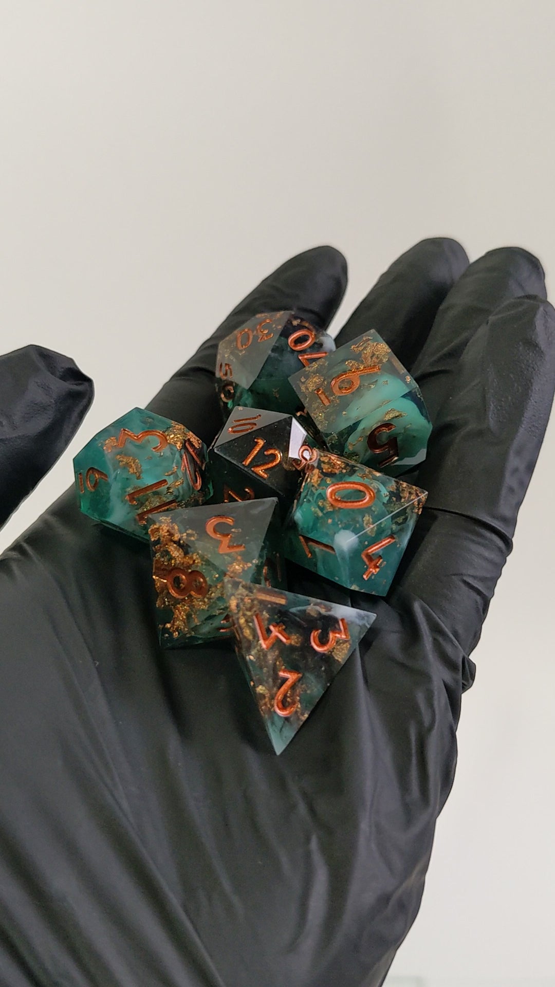 Video of a hand holding sharp edge resin ttrpg dice moving them around to show off the colors