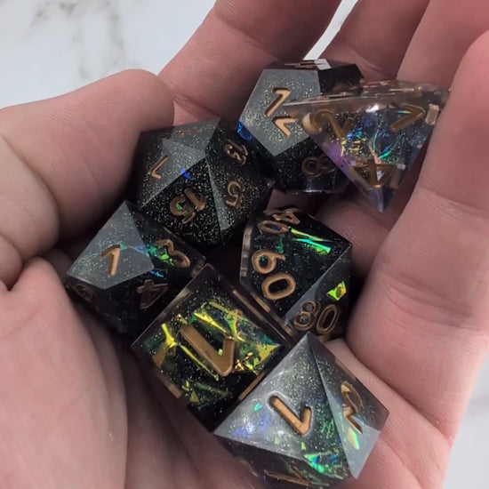 Black and Gold Polyhedral Dice being moved around on hand with only the sound of dice clacking