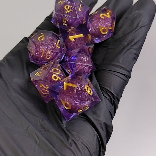 Liquid core dice set shaken in hands, dice set is purple sharp edge resin with gold numbers