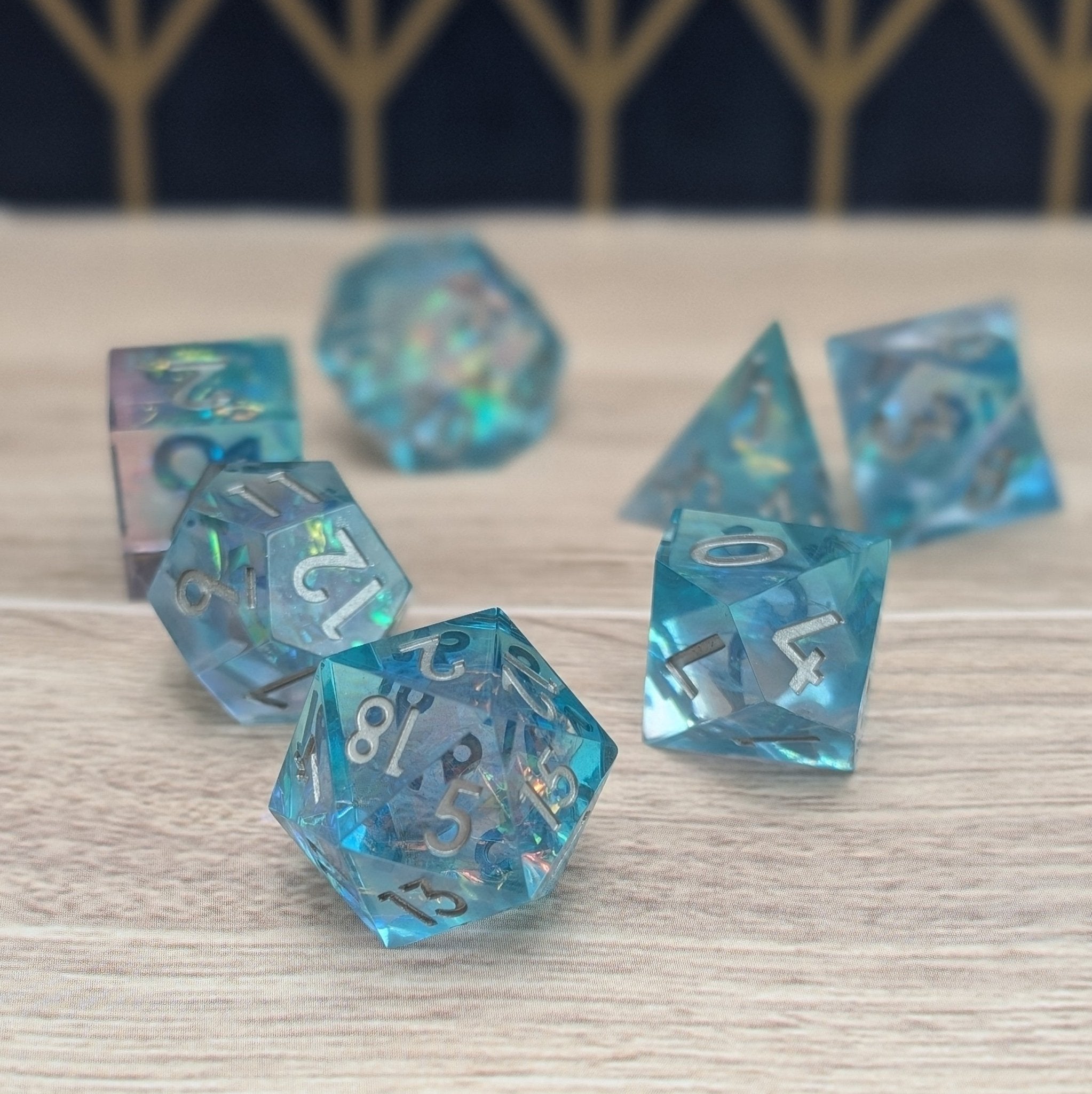 Close-up of Oceanheart Opals sharp edge blue resin dice with silver numbering on woodgrain base