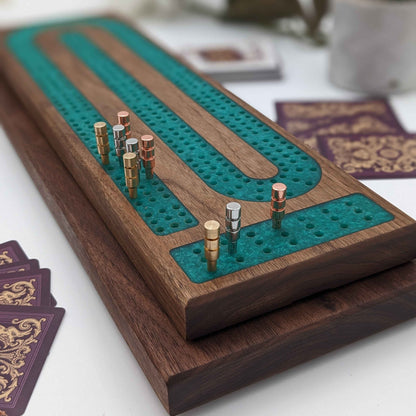 handmade walnut cribbage board with emerald epoxy resin inlay with card and page storage side view